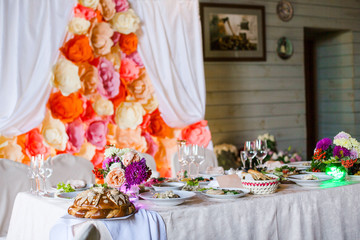 Beautifully decorated presidium table with flowers and different food snacks and appetizers with sandwich, wine glass, plate, apple on corporate event or wedding celebration