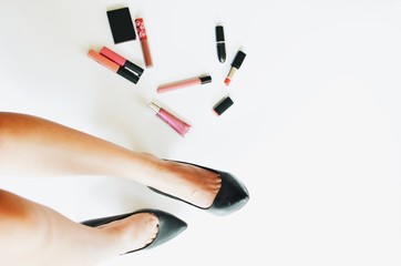 top view woman legs wearing black shoes with cosmetics set on white background.