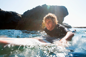Man lying on surfboard in the water