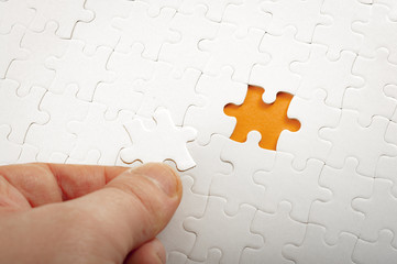 Completing final task, missing jigsaw puzzle pieces and business concept with hand holding the...