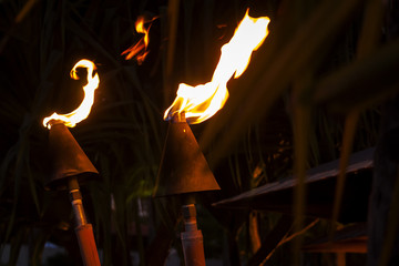 Iconic torches specific to Hawaii islands burning at night on a summer night