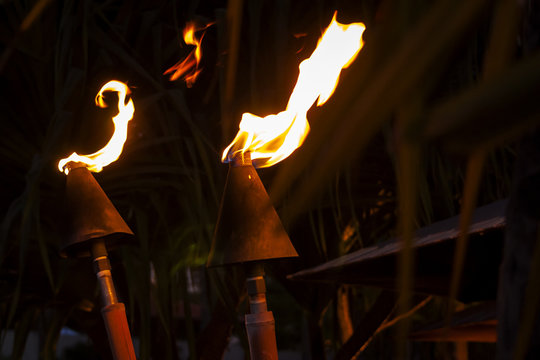 Iconic torches specific to Hawaii islands burning at night on a summer night