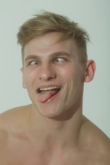 man squinting eyes and showing tongue on funny face