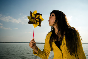Girl blowing at toy windmill