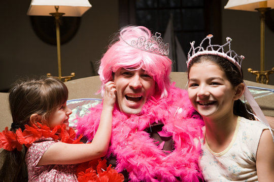 A father and his daughters playing fancy dress