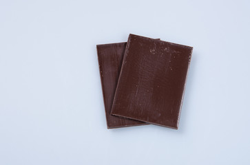 Chocolate bar or pieces on a background.