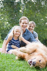 Family in the park with golden retriever