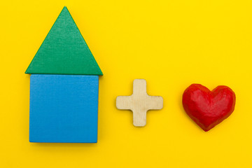 Figurine of the house plus heart on a yellow background