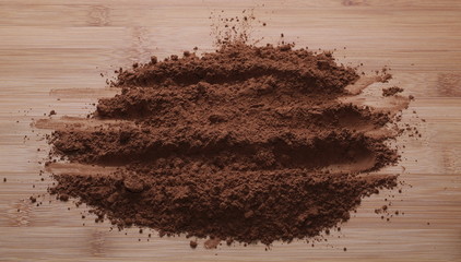 pile cocoa powder on wooden table