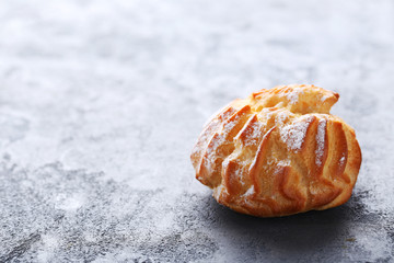 Homemade profiterole with cream on grey wooden table