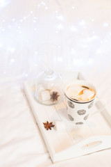 Breakfast in bed - wooden tray with cup of coffee and marshmallows, cozy hygge home style