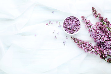 Lilac flowers in bowl on white cloth