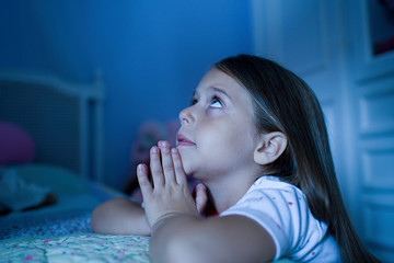 Girl saying bedtime prayers
