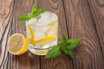 cool drink with lemon and mint on a wooden background