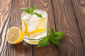cool drink with lemon and mint on a wooden background