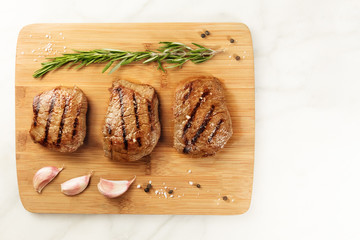 Three slices of cooked meat with seasoning and copyspace