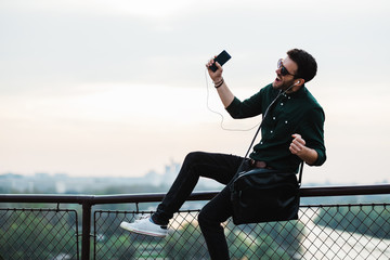 Young man listening to the music on his smartphone