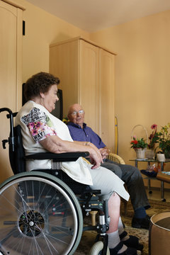 Two seniors sitting in their room in rest home chatting about the good old times