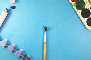 A row of painter brush closeup on artistic canvas. One brush of insulator on a blue background with...