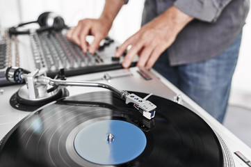 a dj using a turntable and mixing board
