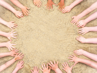 Kreis aus Kinderhänden im Sand - obrazy, fototapety, plakaty