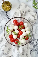 Mozzarella and cherry tomatoes salad with pesto sauce 