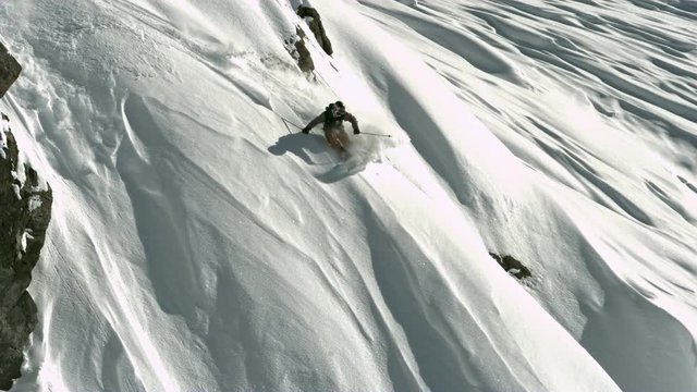 Skier skiing down a steep mountain in slow motion