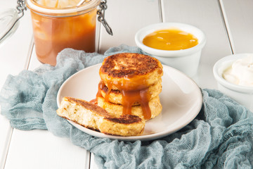 Cottage cheese pancakes on a wooden white background, horizontal, selective focus
