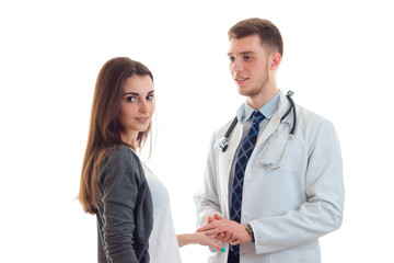 smiling charming girl looks straight and stands near a doctor in a white lab coat