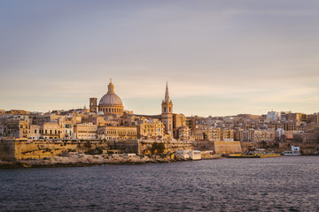 Obraz na płótnie Canvas Valletta skyline at sunset with Basilica, viewed from Sliema, Malta