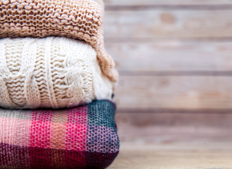 stack of clothes from knitted knitwear on a wooden background