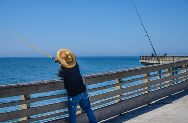 Man fishing in Ocean Beach  pier San Diego California  for past time