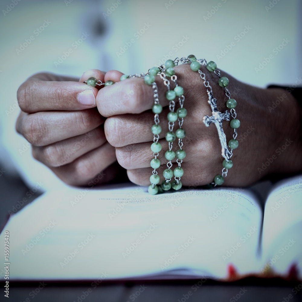 Wall mural praying hands of woman with rosary and bible