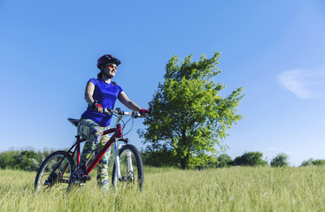 Fototapeta premium Young Woman Riding Mountain Bike in Wilderness.