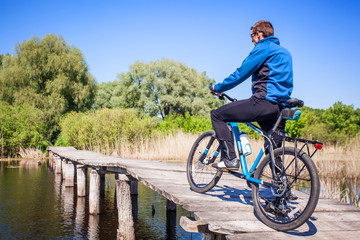 Young bicyclist rides on the bridge