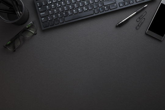 Computer Keyboard With Eyeglasses And Office Supply On Gray Desk