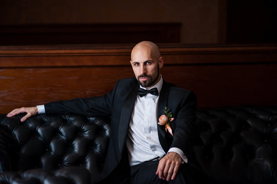 A handsome bald man is an aristocrat.