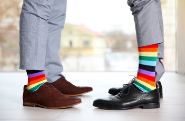 Gay couple with colorful socks on light floor