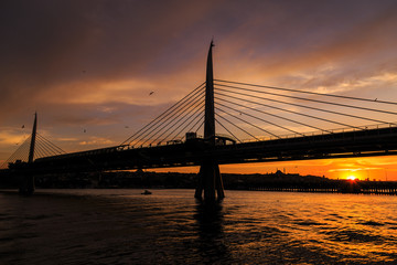 Fototapeta na wymiar Silhouette view of Istanbul metro bridge during the sunset with reverse light
