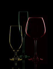 Colored transparent glasses for wine on a black background.