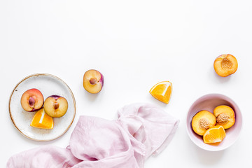 tropical fruits design with orange and peach on fabric white table background top view mock up