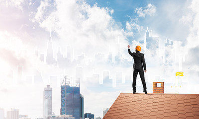 Man architect draw silhouette of modern city on blue sky. Mixed media