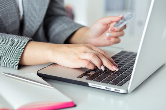 Close up view of businesswoman hands holding credit card and making online purchase