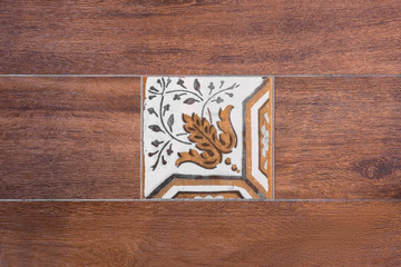 Ceramic tile inserted in wooden plate. Wall and floor decoration.