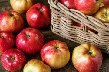 basket with red ripe apples on a brown wooden table