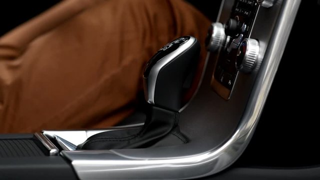 Man changing modes in automatic gearbox. Switching to drive, reverse and neutral