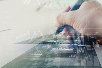 Hand writes with a digital pen. Internet banking, charts and quotes, a modern form of running a business. Double exposure.