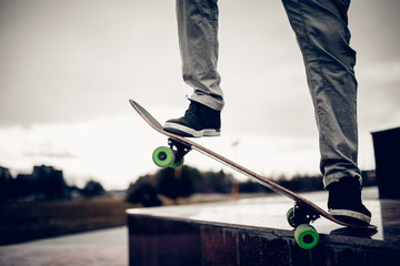skateboarder guy prepares for a stunt on a skateboard and rides along the road. Concept forward to the goal and achieve it.