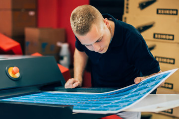 Young man working in printing factory