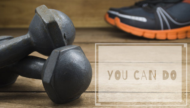 dumbbells and running shoes on wooden floor with the word 'ํYou Can Do' graphic